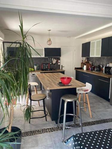 - une cuisine avec une table et quelques tabourets dans l'établissement Maison Familiale Saint-Malo, à Saint-Malo