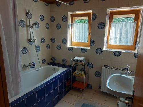 niebiesko-biała łazienka z wanną i umywalką w obiekcie Ferienwohnung Schwarzl w mieście Münster