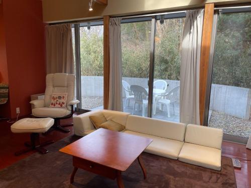 Una sala de estar con un sofá y sillas y una mesa. en Petit Eturn Hakone, en Sengokuhara