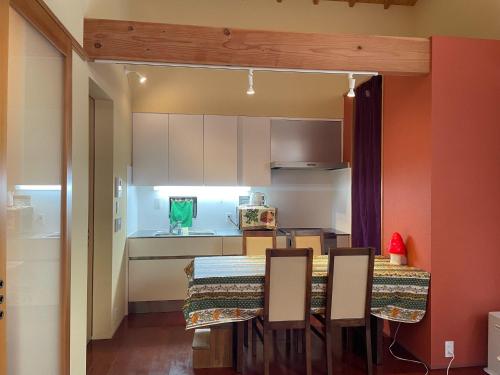 Una cocina con una mesa y sillas en una habitación. en Petit Eturn Hakone, en Sengokuhara