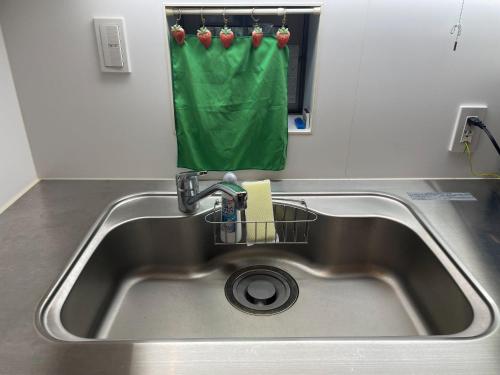 un fregadero de cocina con una toalla verde colgando sobre él en Petit Eturn Hakone, en Sengokuhara