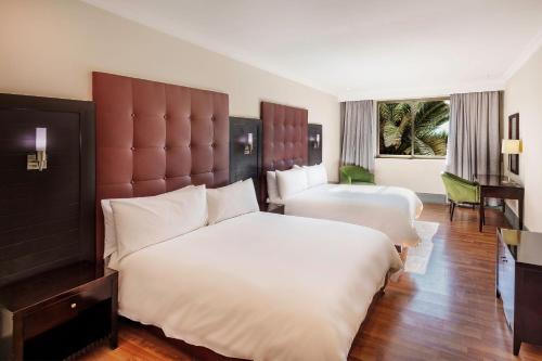 een hotelkamer met 2 bedden en een groot raam bij Protea Hotel by Marriott Lusaka in Lusaka