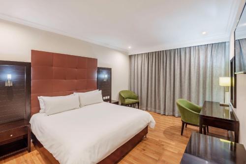 a hotel room with a bed and a desk at Protea Hotel by Marriott Lusaka in Lusaka