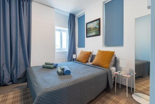 a bedroom with a bed with blue and orange pillows at Blue Diamond Beach Villas in Paphos City