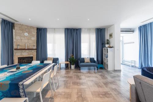 ein Wohnzimmer mit einem Esstisch und ein Wohnzimmer mit blauen Vorhängen in der Unterkunft Blue Diamond Beach Villas in Paphos City