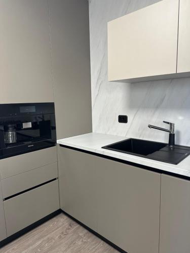 a kitchen with white cabinets and a sink at Vila Petra in Cluj-Napoca