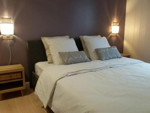 una camera da letto con un grande letto bianco con due cuscini di Le djebel a Cilaos