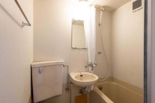 a bathroom with a sink and a toilet and a mirror at Palo Nagasaki in Tokyo