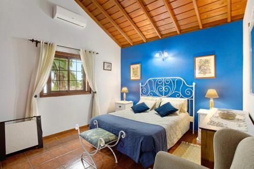 - une chambre avec un lit et un mur bleu dans l'établissement La Roquina, à Tijarafe