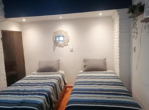 two beds sitting next to each other in a room at LU'UM Master Suites in Taxco de Alarcón