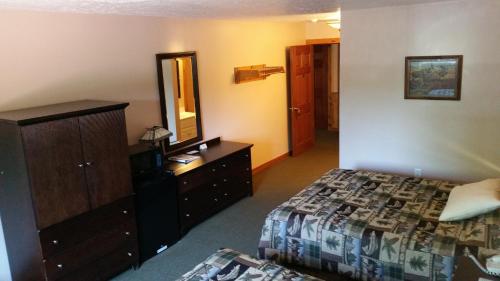1 dormitorio con cama, tocador y espejo en K&G Lodge, en Oswego