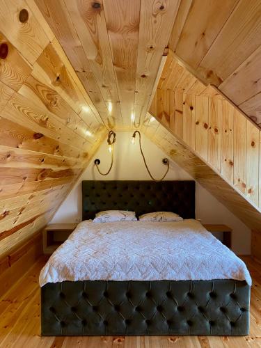 a bedroom with a large bed with a wooden ceiling at Montenegro Dream House in Žabljak