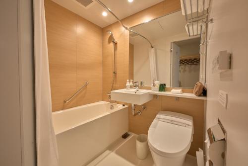 een badkamer met een toilet, een wastafel en een bad bij Hotel Intergate Kanazawa in Kanazawa