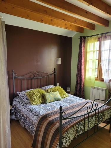 a bedroom with a large bed with a wooden ceiling at Le Charme Normand in Norville