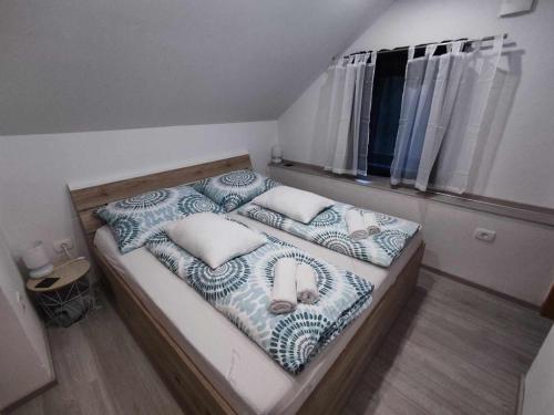 ein kleines Schlafzimmer mit einem Bett mit blauen und weißen Kissen in der Unterkunft Sivka - mountain apartment with sauna in Kobarid