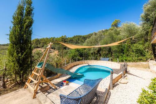 a backyard pool with a slide and a swing set at Ses Solls in Petra