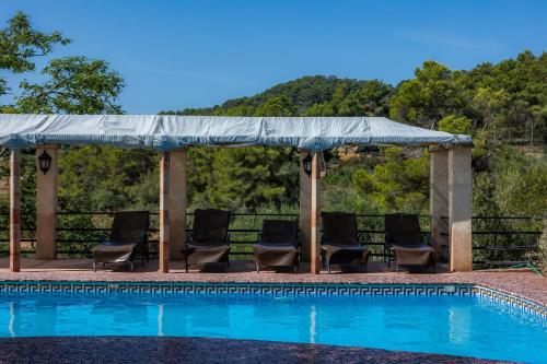 a gazebo with chairs next to a swimming pool at Ses Solls in Petra