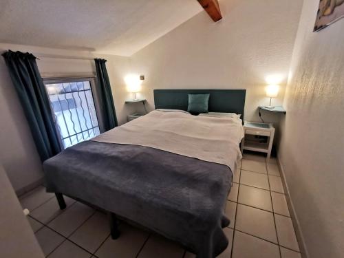 een slaapkamer met een groot bed en een raam bij Ferienhaus am Golf von Saint-Tropez in Cogolin