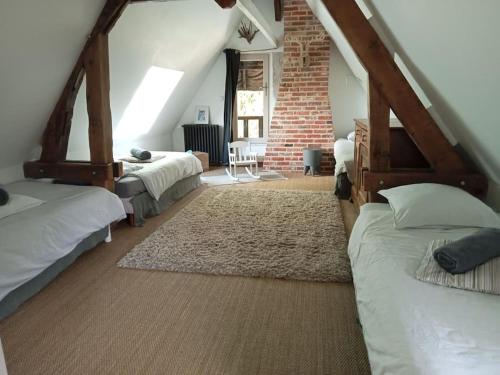 1 dormitorio en el ático con 2 camas y pared de ladrillo en Maison à colombages près de Deauville, Trouville, en Formentin