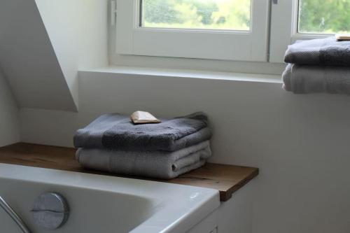 a bathroom with towels on top of a sink at Maison à colombages près de Deauville, Trouville in Formentin