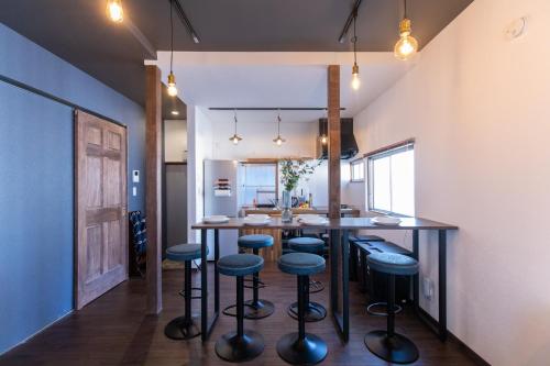 a kitchen with a large table and stools at 和氣会々新大久保 Wakiaiai Shinokubo in Tokyo