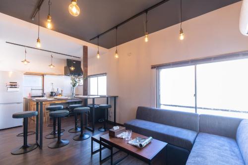 a living room with a blue couch and a kitchen at 和氣会々新大久保 Wakiaiai Shinokubo in Tokyo