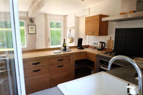 une cuisine avec un évier et une cuisinière four supérieur dans l'établissement Maison à colombages près de Deauville, Trouville, à Formentin