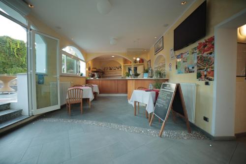 a restaurant with tables and chairs and a chalkboard at Hotel Bellavista in San Bartolomeo al Mare