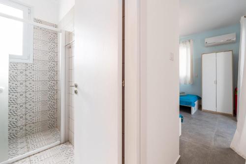a bathroom with a walk in shower next to a door at Blue Diamond Beach Villas in Paphos City