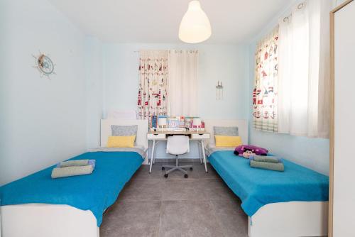 two beds in a room with a desk and a table at Blue Diamond Beach Villas in Paphos City
