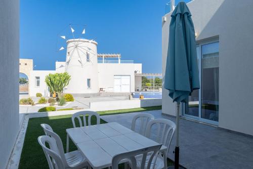 a table and chairs and an umbrella on a patio at Blue Diamond Beach Villas in Paphos City