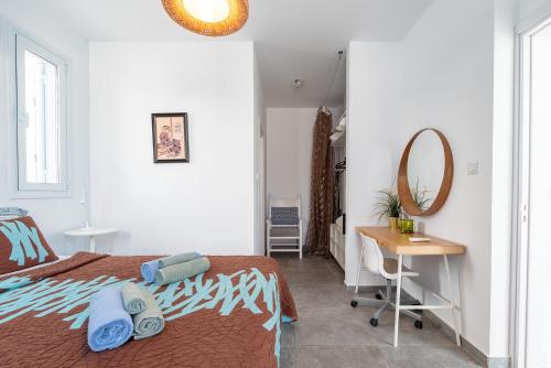 a bedroom with a bed and a desk and a mirror at Blue Diamond Beach Villas in Paphos City