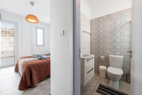 a white bathroom with a bed and a toilet at Blue Diamond Beach Villas in Paphos City