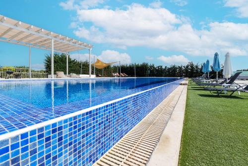a swimming pool with chairs and umbrellas at a resort at Blue Diamond Beach Villas in Paphos City