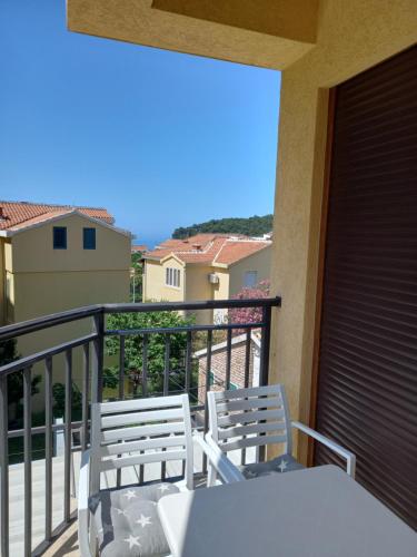 a balcony with two chairs and a table on a balcony at Apartman Pejovic in Petrovac na Moru