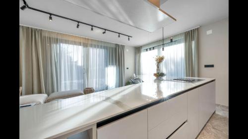 a white kitchen with a large white counter top at Villa 8 - luxury roof top pools in Srima
