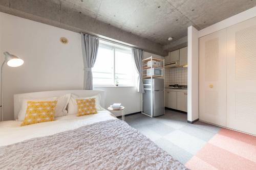 a bedroom with a large bed and a kitchen at Park Residence in Sapporo
