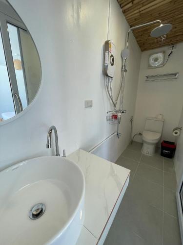 a bathroom with a sink and a mirror and a toilet at Nice Sea Resort in Srithanu