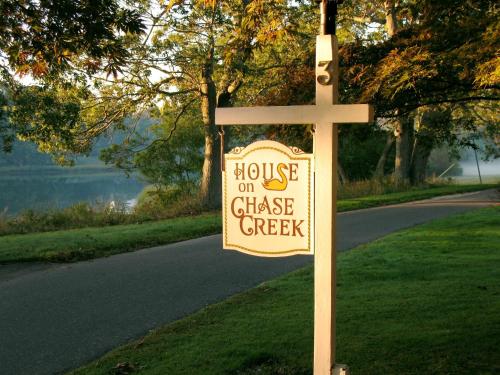 a wooden cross with a sign on a street at House on Chase Creek in Shelter Island Heights