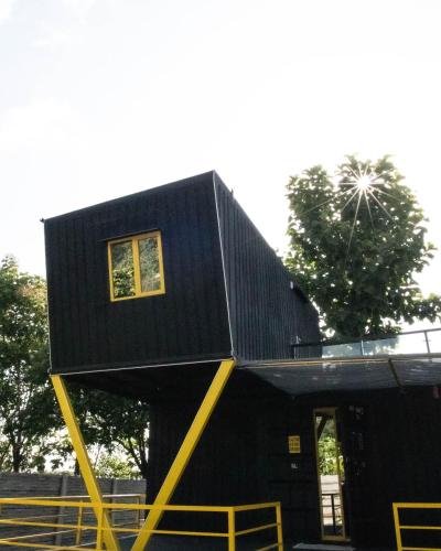 a house with a black roof on a yellow structure at 16 Bedouin Private Pool Villa in Hosūr