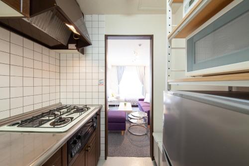 a small kitchen with a stove and a window at Park Residence in Sapporo