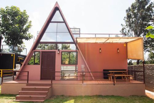 a small pink house with a triangular roof at 16 Bedouin Private Pool Villa in Hosūr