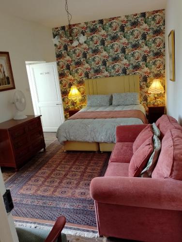 une chambre avec un lit et un canapé dans l'établissement Manoir La Breuille, à Montmoreau