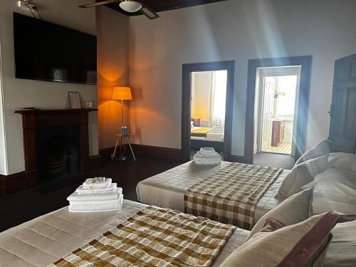 a hotel room with two beds and a fireplace at The Family Hotel in Maitland
