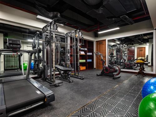 a fitness room with a gym with tread machines at GRAND HOTEL du LAC Hanoi in Hanoi