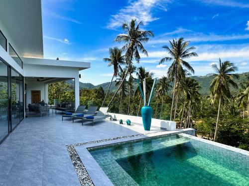 een huis met een zwembad en palmbomen bij VILLA CAMILLE - SEAVIEW - 4 Bedrooms in Koh Samui 