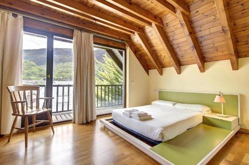 1 dormitorio con 1 cama grande y balcón en Arroquets, en Vielha