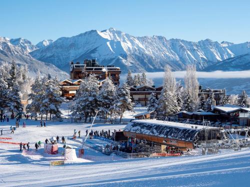 a group of people on a ski slope in the mountains at SOWELL RESIDENCES Pra Loup in Pra-Loup
