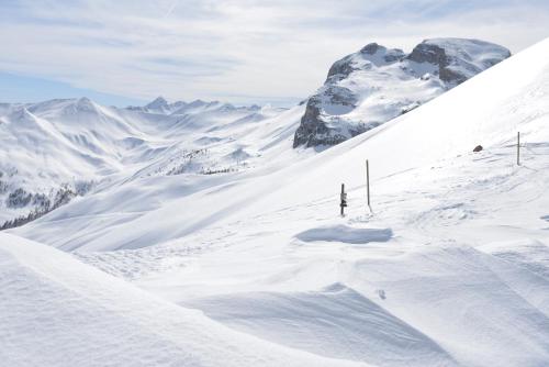 a person is skiing down a snow covered mountain at SOWELL RESIDENCES Pra Loup in Pra-Loup