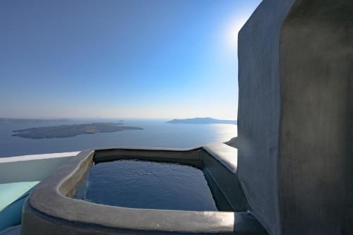 a bath tub filled with water next to the ocean at Sophia Luxury Suites in Imerovigli